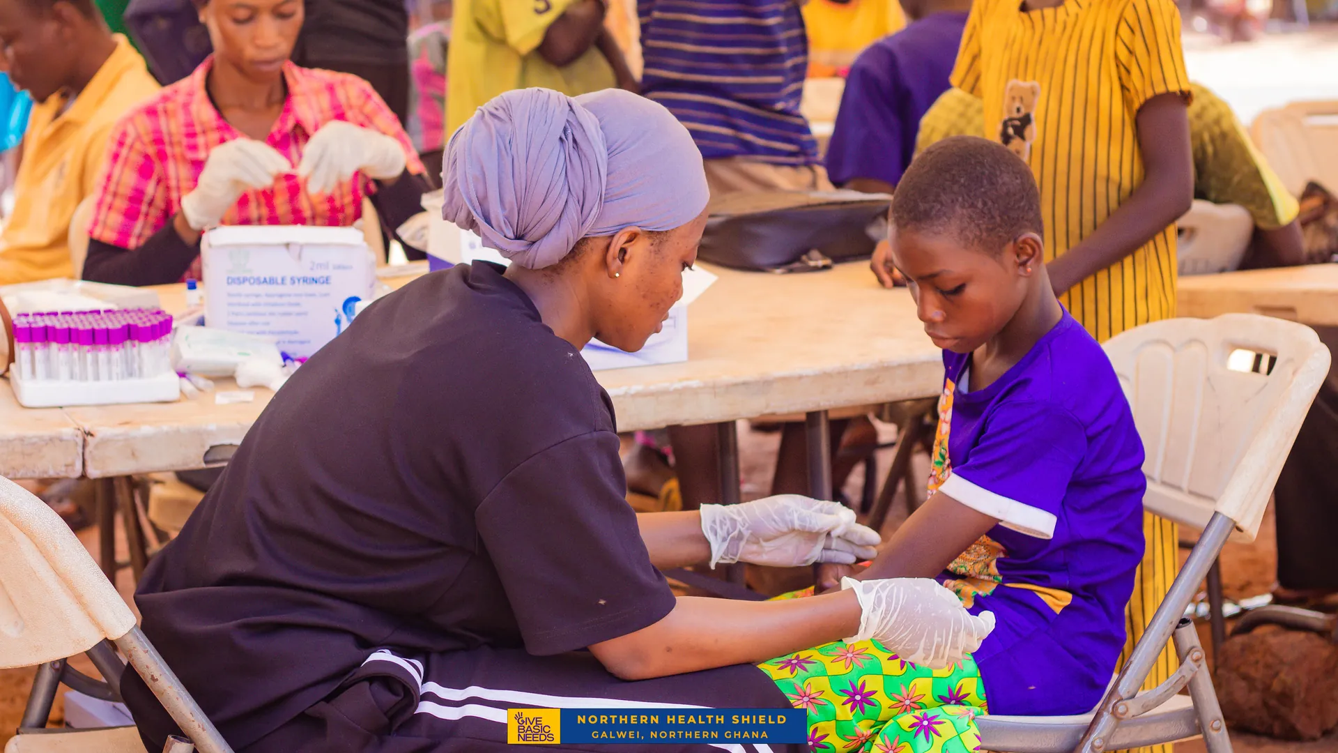A health worker takes a blood sample from a child at a Northern Health Shield outreach in Galwei, Northern Ghana