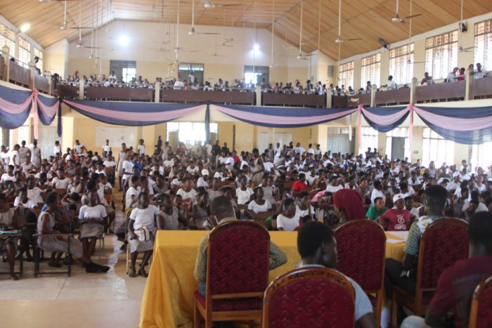 students gather in a hall for a medical screening and health education at a giving event held by give basic needs