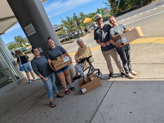 volunteers at the giving event by give basic needs holding boxes with the breakfast burritos in them
