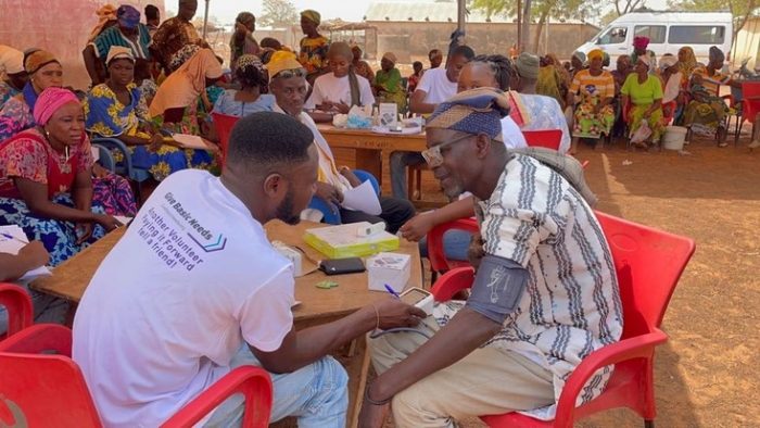 a medical worker with a give basic needs shirt on administers a medical test